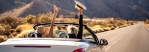 Two happy young girls driving